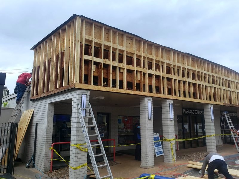Commercial second-story framing above an occupied ground floor.