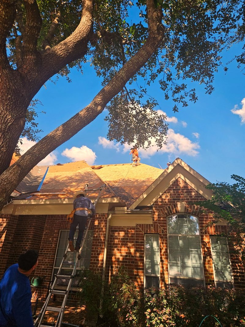 Roof repair in progress on a residential home under blue sky.