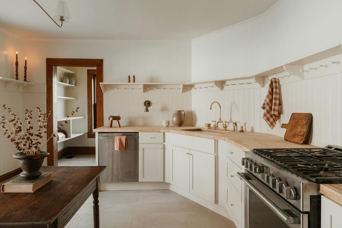 A finished Level Headed Construction kitchen — cream cabinetry, wood countertops, and brass fixtures.
